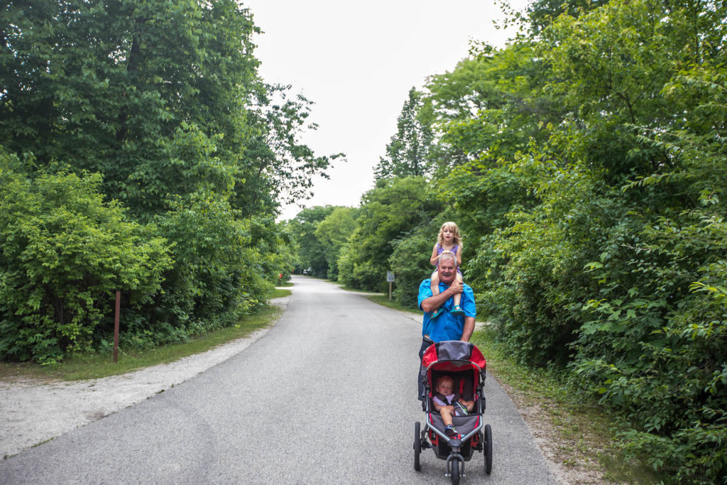 grandpa walking with grandkids at campground